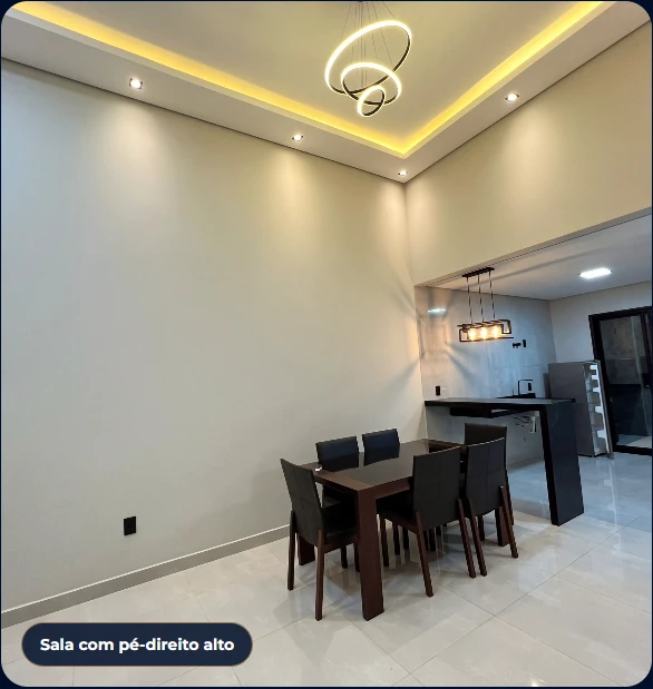 Sala ampla e cozinha integradas, com pé-direito alto e iluminação decorativa